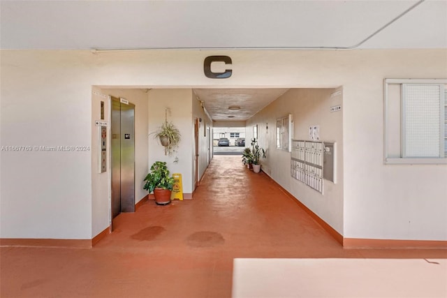 corridor featuring concrete flooring and elevator