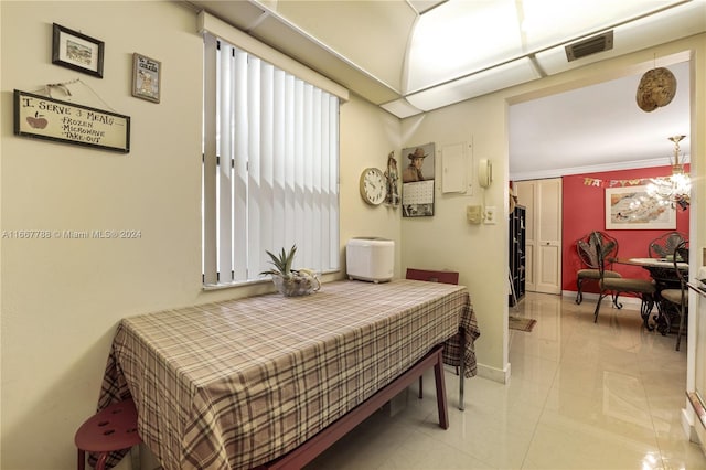 bedroom featuring an inviting chandelier, light tile patterned flooring, and crown molding