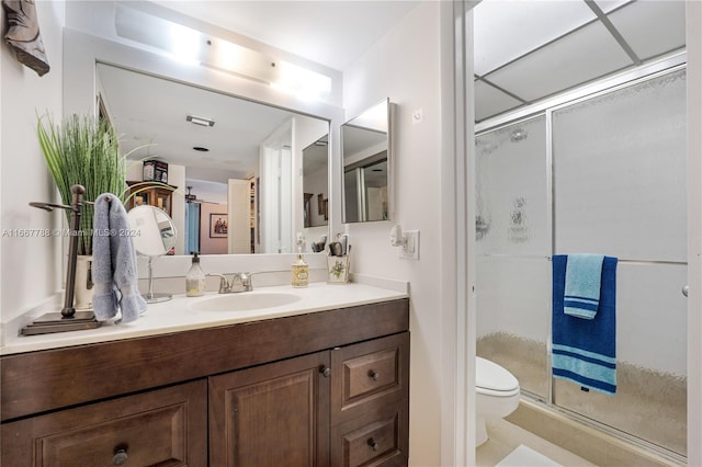 bathroom with vanity, tile patterned flooring, toilet, and a shower with door