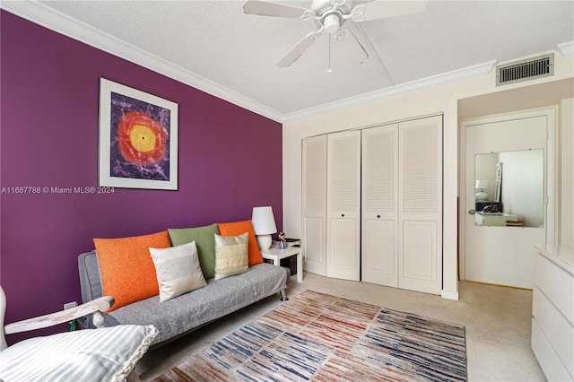 carpeted living room featuring ceiling fan, a textured ceiling, and crown molding