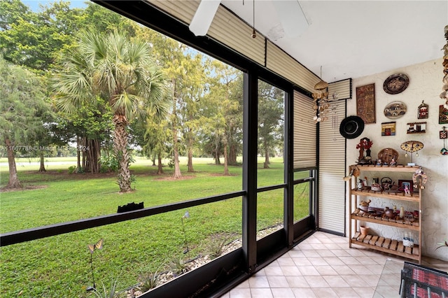 unfurnished sunroom with ceiling fan and plenty of natural light