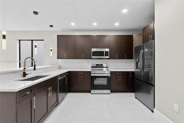 kitchen with dark brown cabinetry, hanging light fixtures, light tile patterned floors, sink, and stainless steel appliances