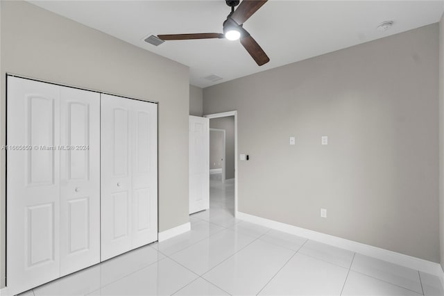 unfurnished bedroom featuring a closet, ceiling fan, and light tile patterned flooring