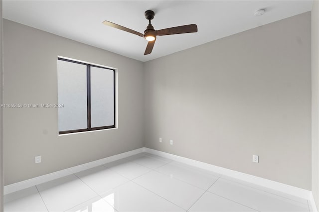 tiled empty room featuring ceiling fan