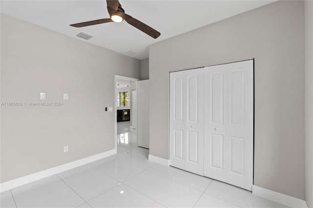 unfurnished bedroom featuring light tile patterned floors, ceiling fan, and a closet