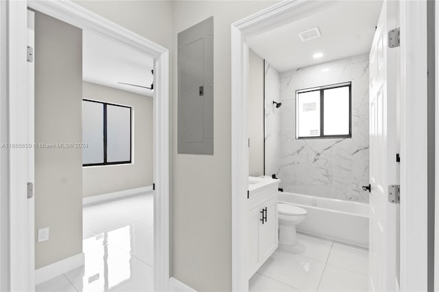 full bathroom featuring tiled shower / bath, vanity, electric panel, tile patterned floors, and toilet