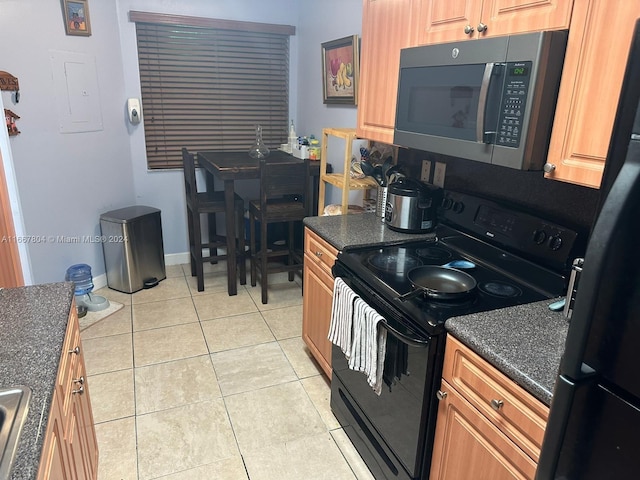 kitchen with black appliances, electric panel, light tile patterned floors, and sink