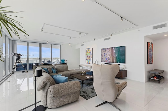 living room featuring light tile patterned floors and a wall of windows