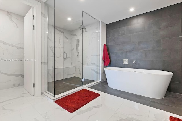 bathroom featuring separate shower and tub and tile walls