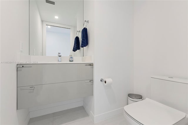 bathroom featuring tile patterned flooring, vanity, and toilet