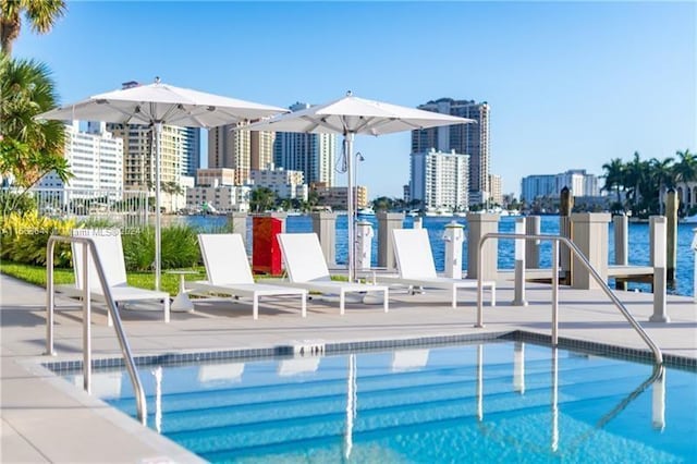 view of pool featuring a patio and a water view