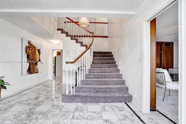 staircase featuring a notable chandelier