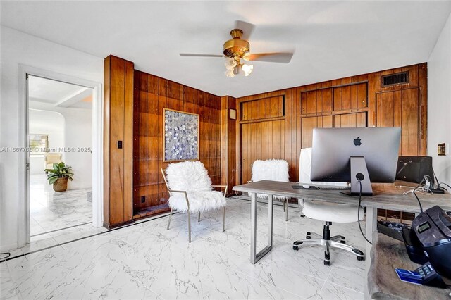 home office with ceiling fan and wooden walls