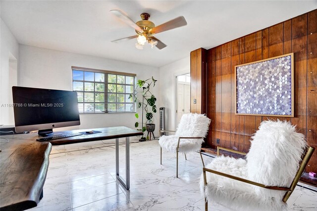 office area featuring ceiling fan and wooden walls