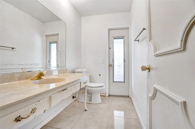 bathroom with tile patterned flooring, vanity, and toilet