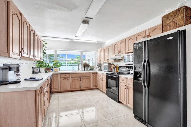 kitchen with sink, light tile patterned floors, and black appliances