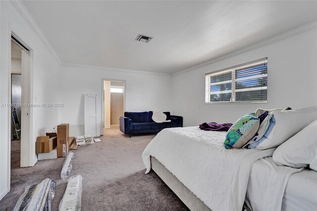 bedroom with ensuite bath, crown molding, and carpet