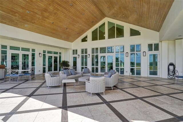 sunroom with lofted ceiling, wooden ceiling, a wealth of natural light, and french doors