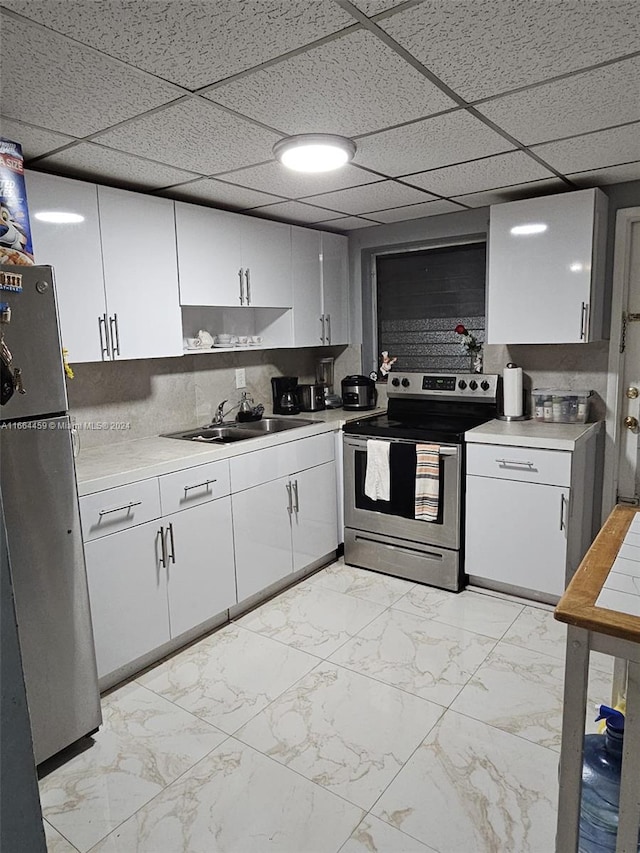 kitchen with appliances with stainless steel finishes, backsplash, sink, and a paneled ceiling