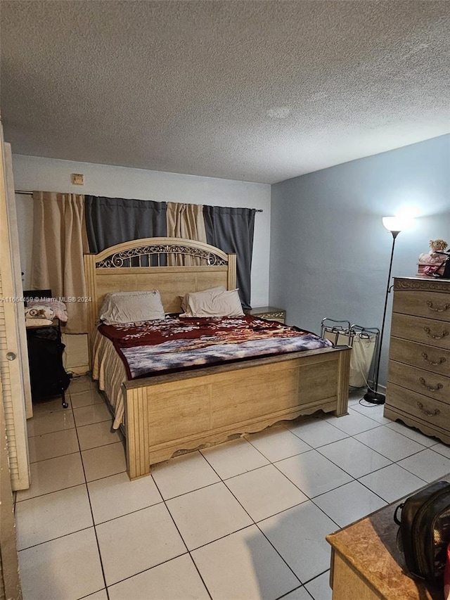 bedroom with a textured ceiling and light tile patterned floors