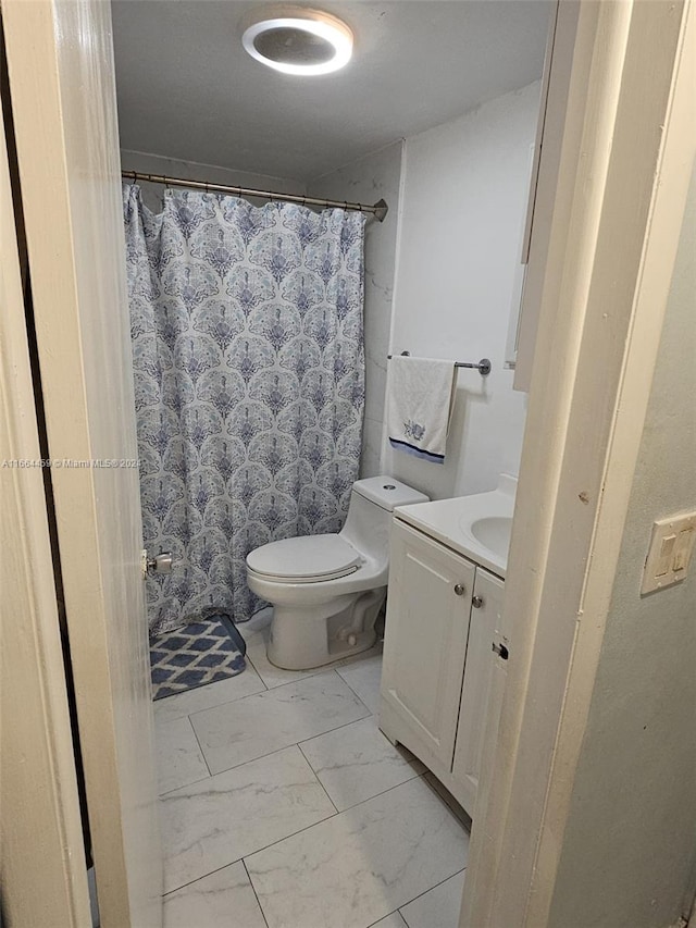 bathroom featuring curtained shower, vanity, and toilet