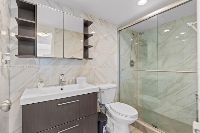 bathroom featuring walk in shower, tile walls, vanity, and toilet