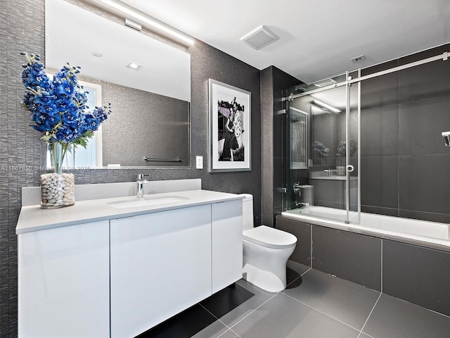 full bathroom featuring vanity, combined bath / shower with glass door, tile patterned floors, and toilet