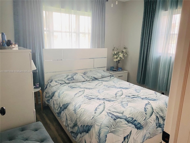 bedroom with dark wood-type flooring and multiple windows