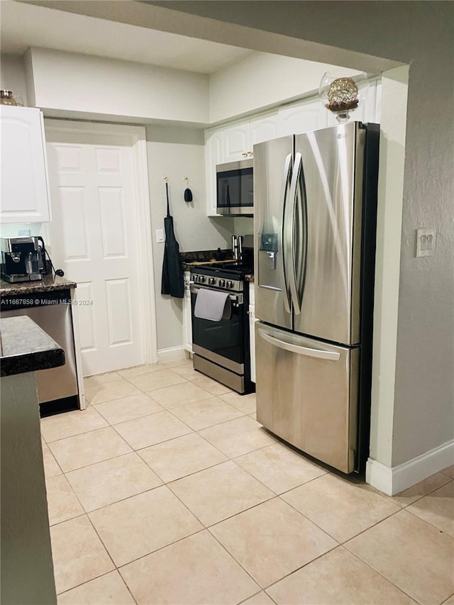 kitchen with white cabinets, light tile patterned flooring, and appliances with stainless steel finishes