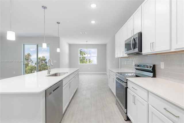 kitchen with white cabinets, a wealth of natural light, appliances with stainless steel finishes, and sink