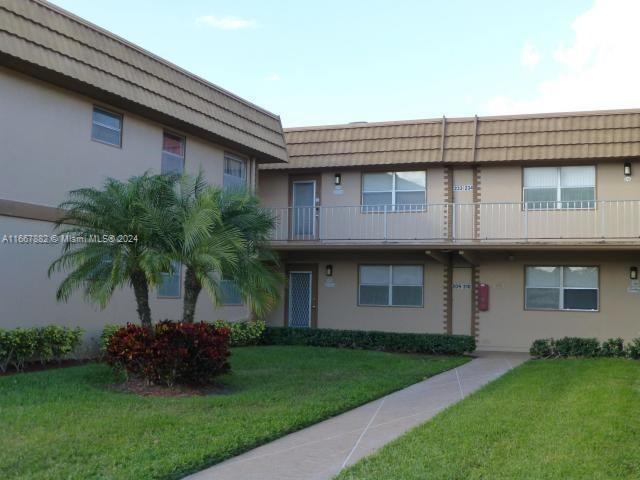 view of front of house featuring a balcony and a front yard