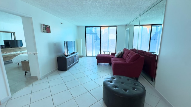 living room with a textured ceiling, light tile patterned flooring, and expansive windows