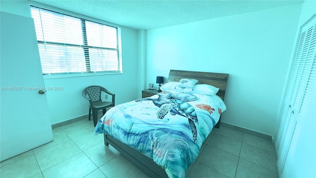 bedroom featuring light tile patterned flooring and a textured ceiling