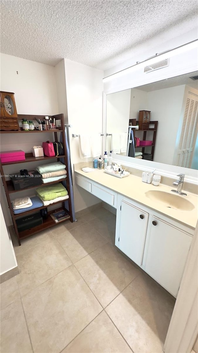 bathroom with tile patterned flooring, a textured ceiling, and vanity