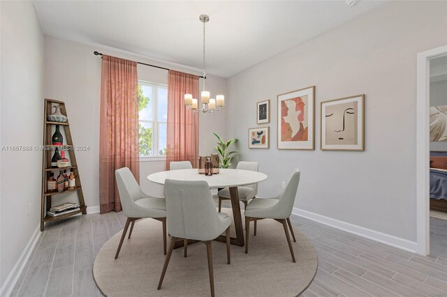 dining area featuring light hardwood / wood-style floors and an inviting chandelier