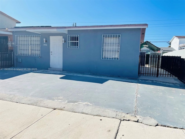 view of front of property with fence and stucco siding