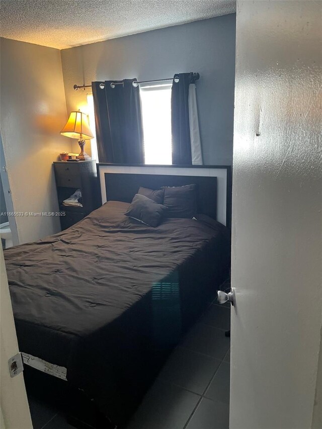 bedroom with tile patterned floors and a textured ceiling