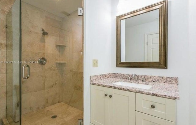 bathroom featuring vanity and a shower with shower door