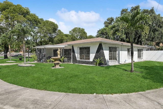 view of front of house with a front yard, fence, and stucco siding