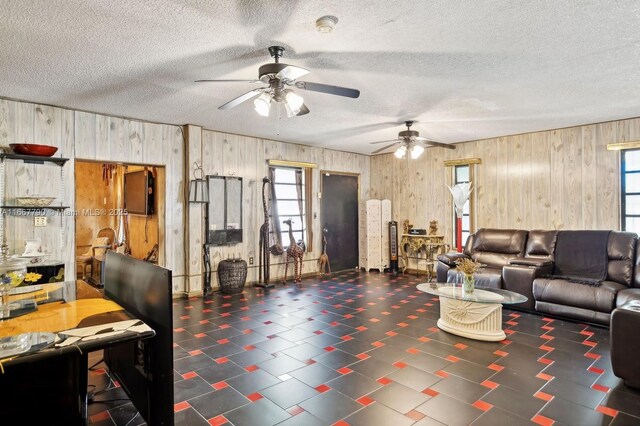 living room featuring ceiling fan and a textured ceiling