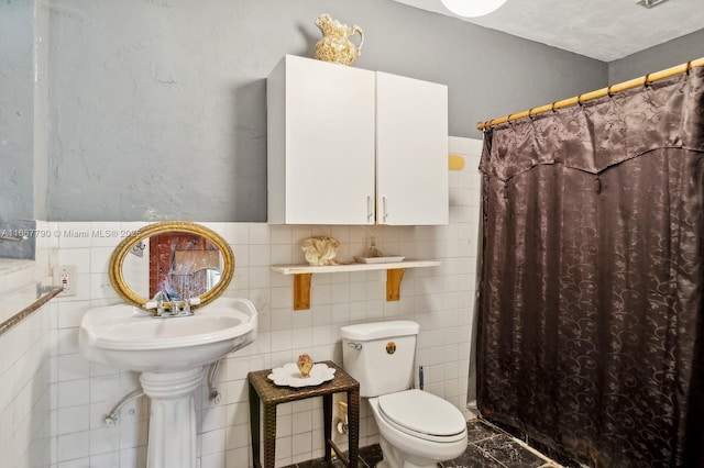 full bathroom featuring curtained shower, toilet, and tile walls