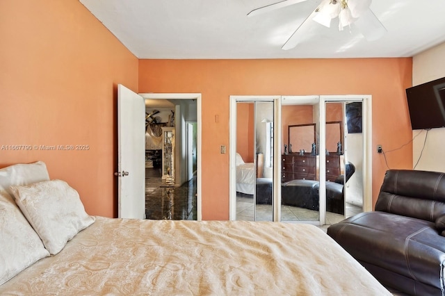 bedroom featuring a ceiling fan and multiple closets