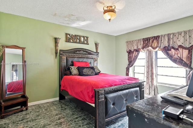 bedroom with a textured ceiling and baseboards