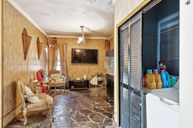 living area with ornamental molding and stone floors