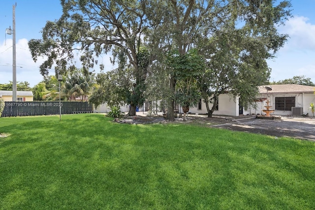 view of yard featuring cooling unit and fence