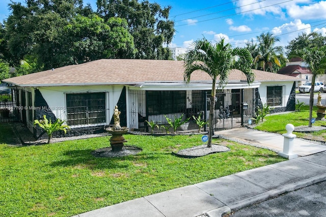 single story home featuring roof with shingles, a front lawn, and stucco siding