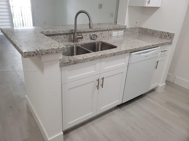 kitchen with light stone counters, dishwasher, light hardwood / wood-style floors, and white cabinetry