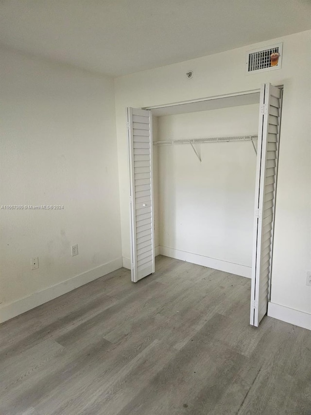 unfurnished bedroom with hardwood / wood-style flooring and a closet