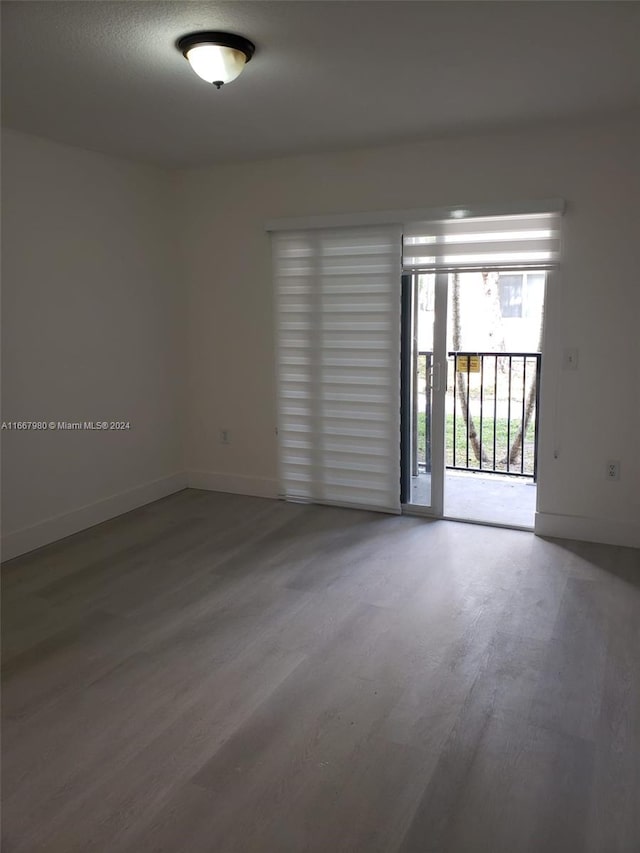 spare room featuring baseboards and wood finished floors