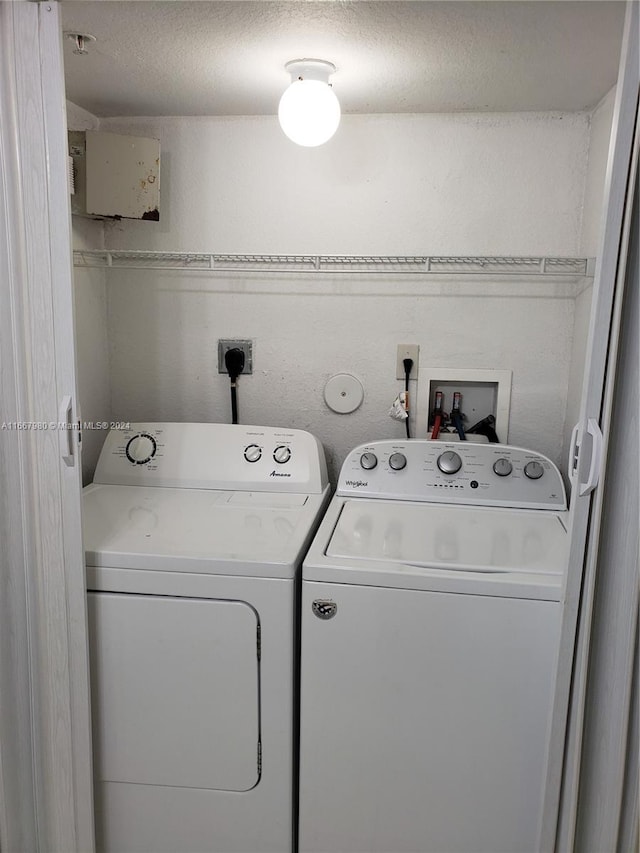 clothes washing area featuring a textured ceiling and washing machine and dryer